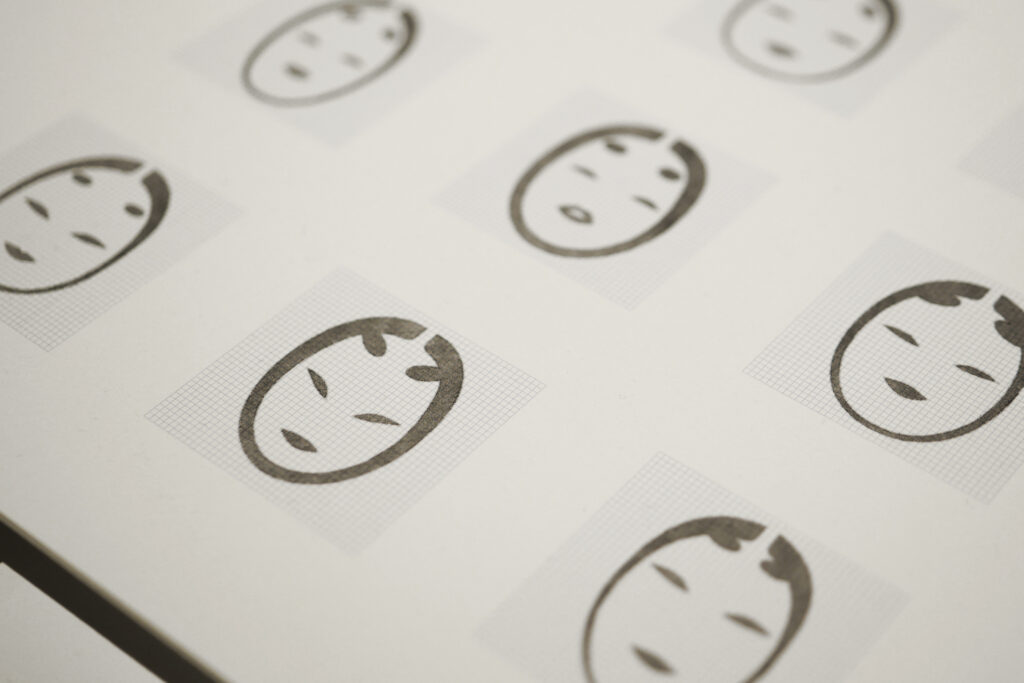 Sketches exploring Noh mask expressions as references for pictogram creation.