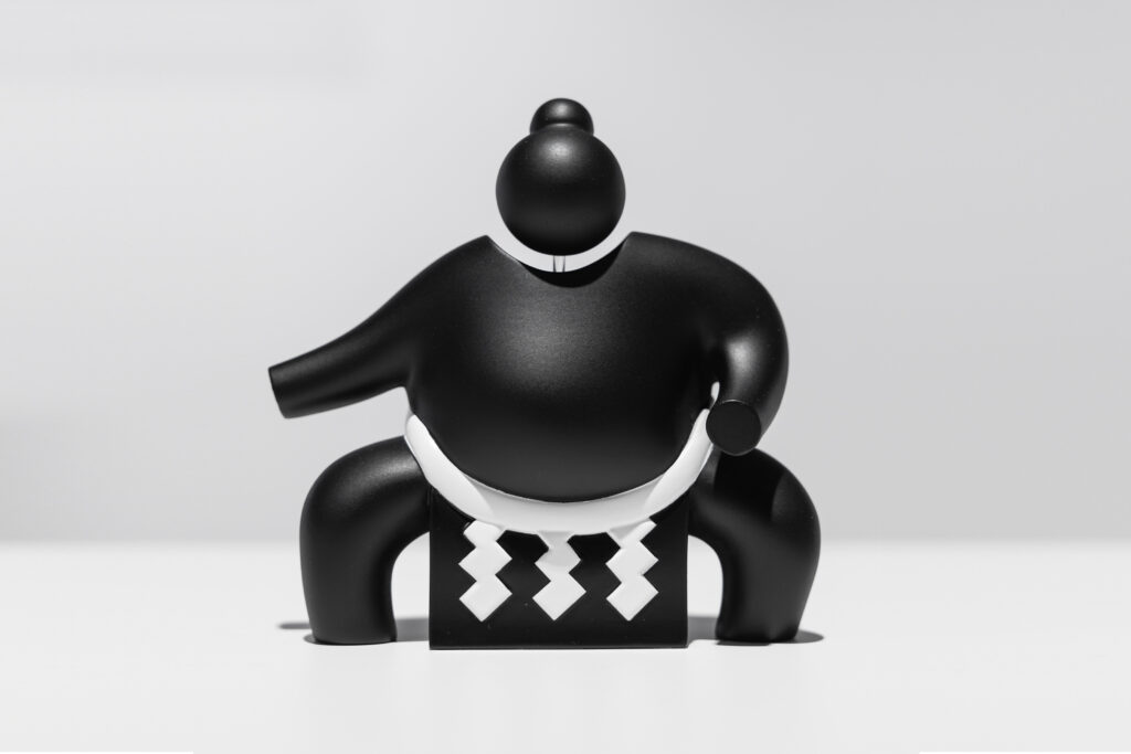 3D sculpture of a sumo pictogram, highlighting motion and form.